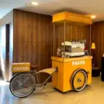 Estação bike coffee amarela com testeira de madeira personalizada PANVA e máquina de espresso.